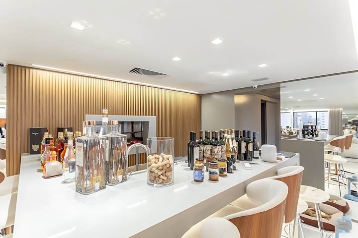 Bar com bancada clara e painel em madeira ripada, apartamento em Petrópolis, Porto Alegre