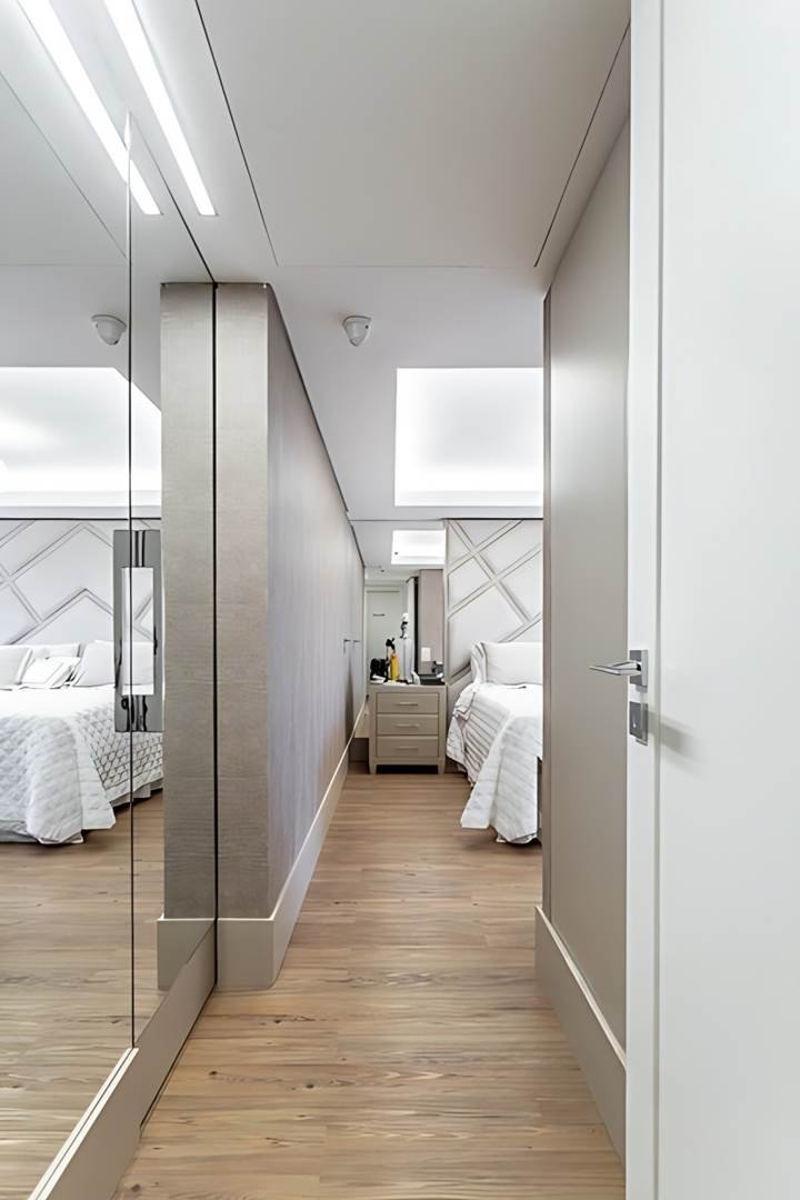 Circulação das suítes, com espelho e portas em tom claro, apartamento em Petrópolis, Porto Alegre